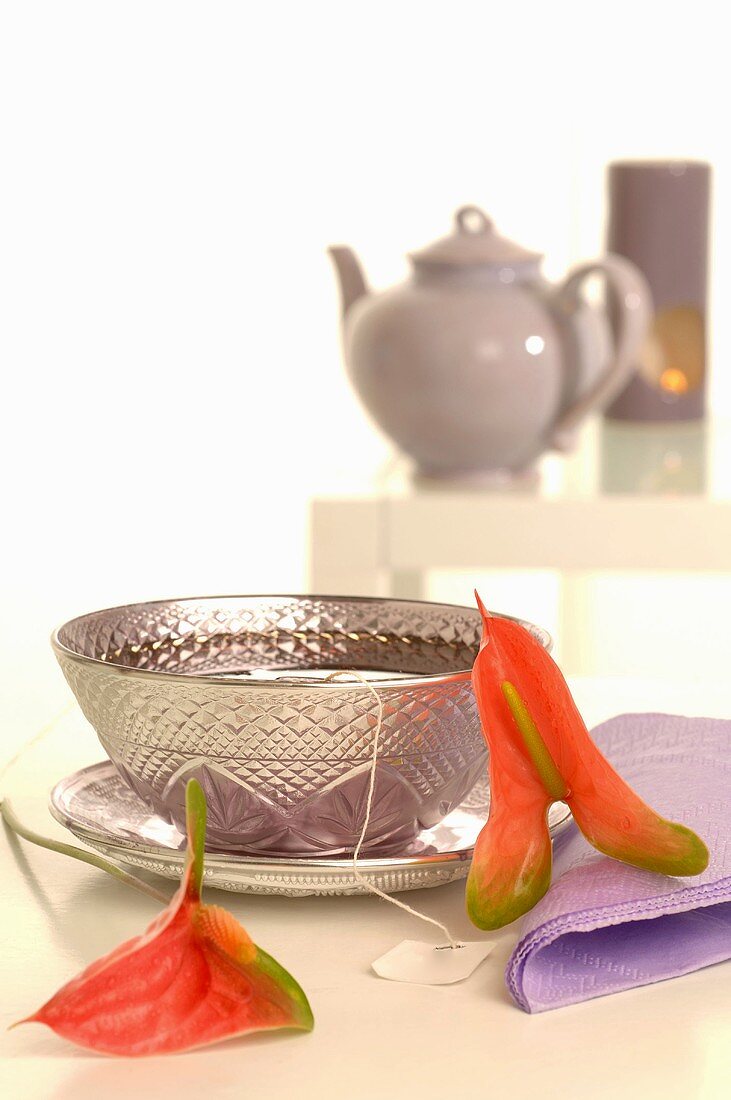 Tea in silver cup and saucer with calla lilies