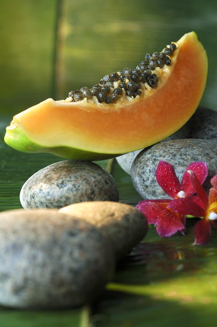 Wedge of papaya on stones