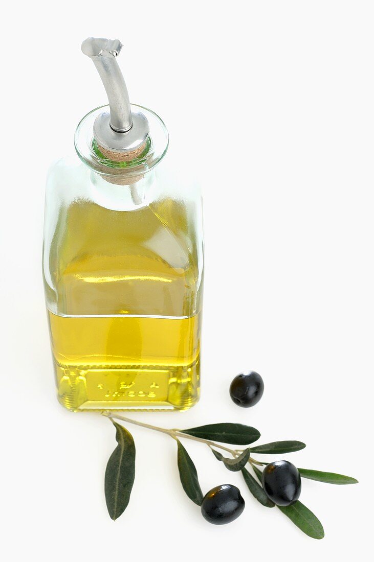 Olive oil, olive sprig and black olives