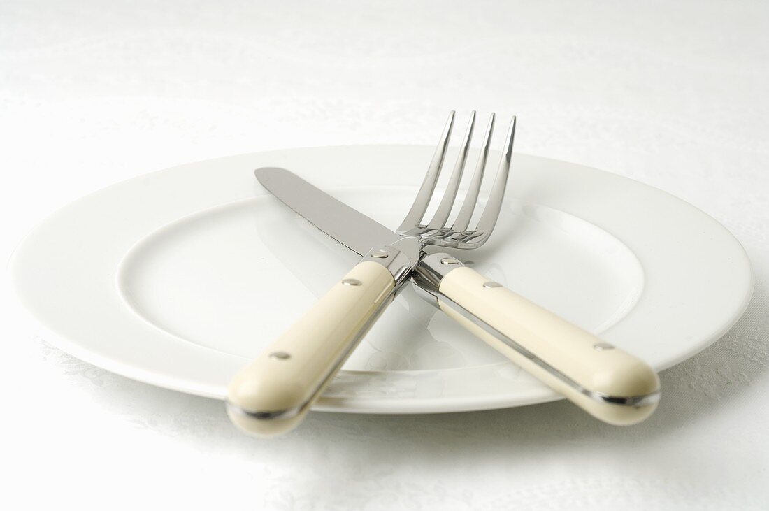 Knife and fork on white plate