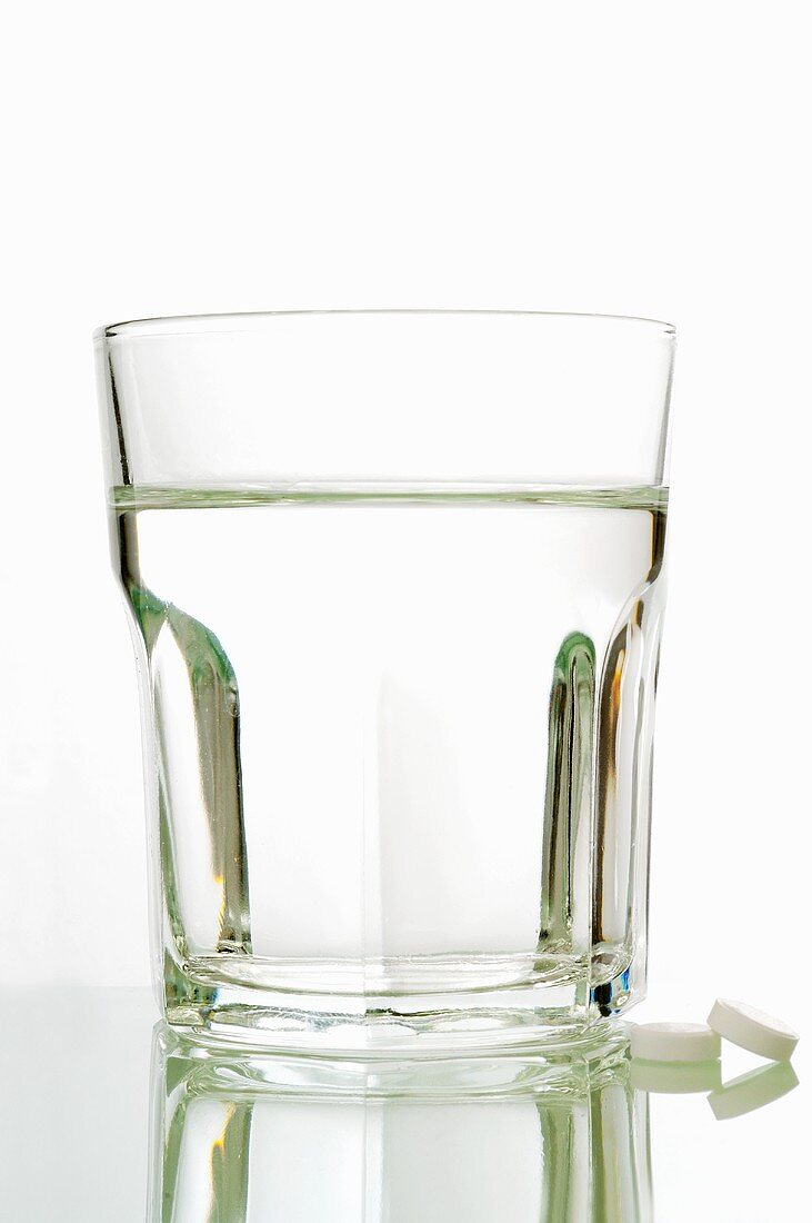 Schüssler Salz Tabletten mit einem Glas Wasser