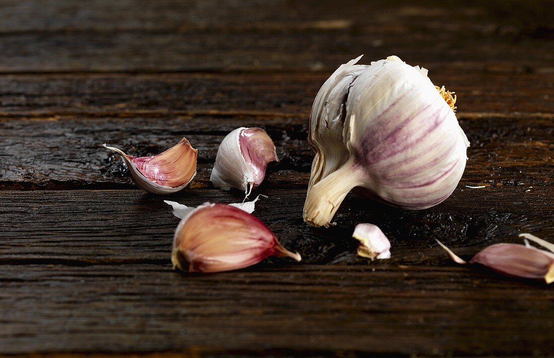 Garlic bulb and cloves of garlic on wooden background