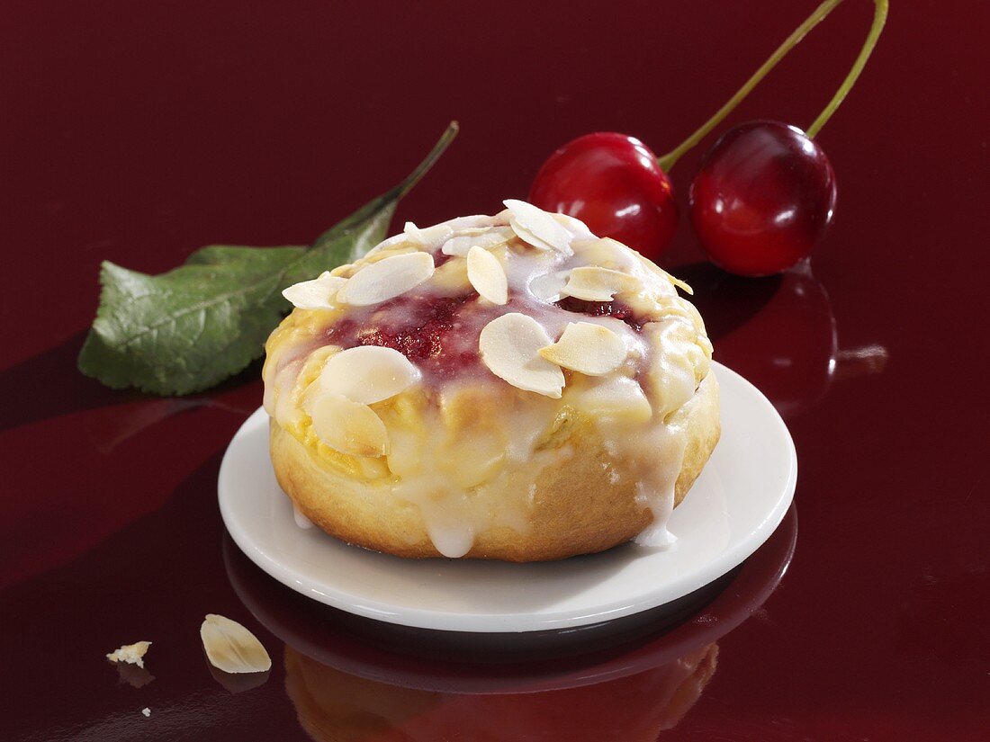 Iced cherry bun with flaked almonds