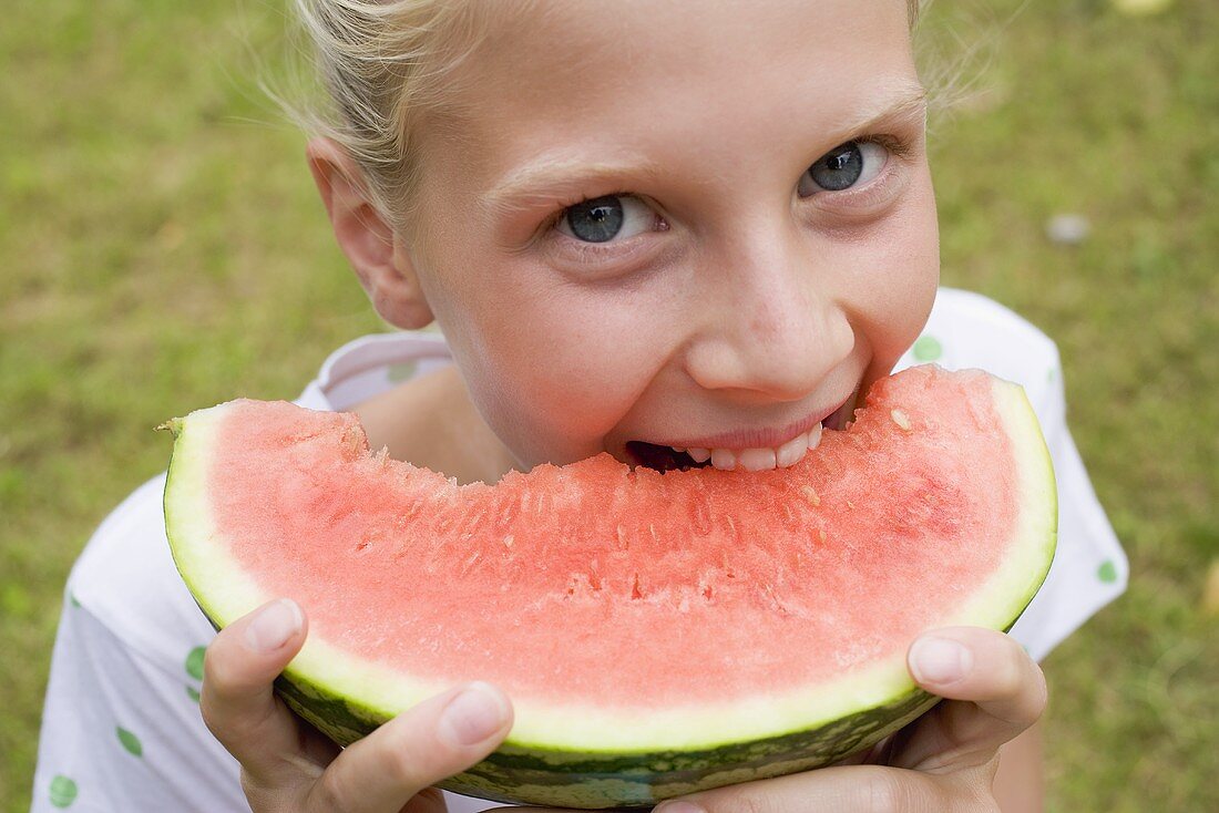 Mädchen beisst in Wassermelone