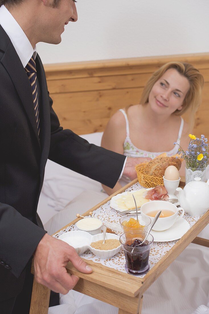 Man bringing woman breakfast in bed