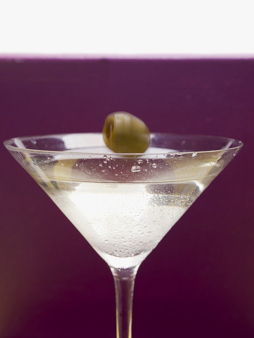 Olive falling into glass of Martini
