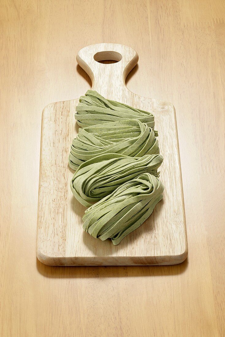 Spinach fettuccine on wooden board
