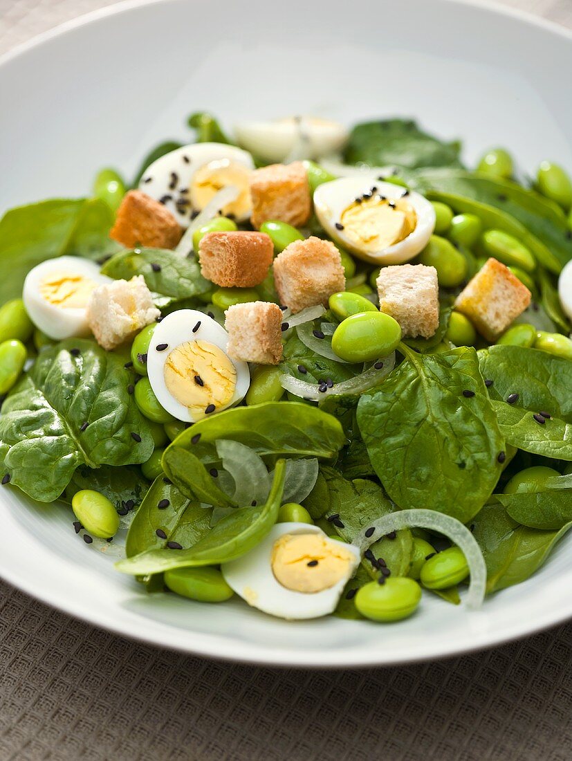 Spinach salad with soya beans, quails' eggs and croutons