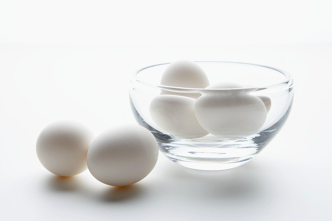 weiße Eier in und neben einem Glasschälchen