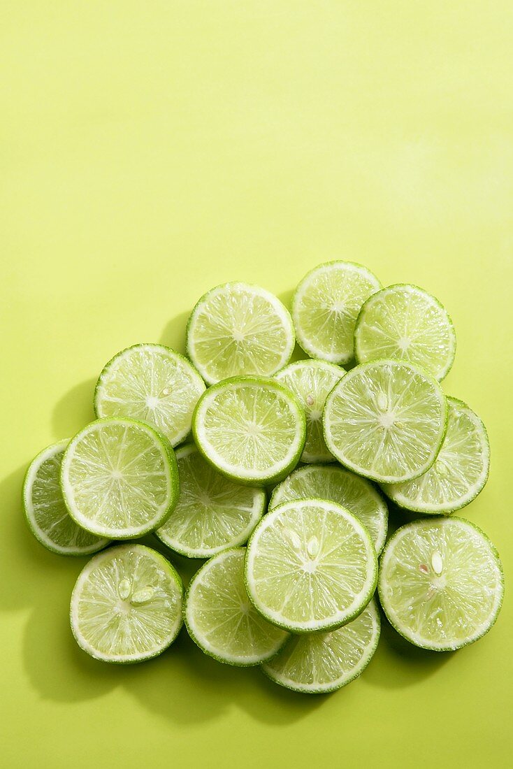 Lime slices on green background