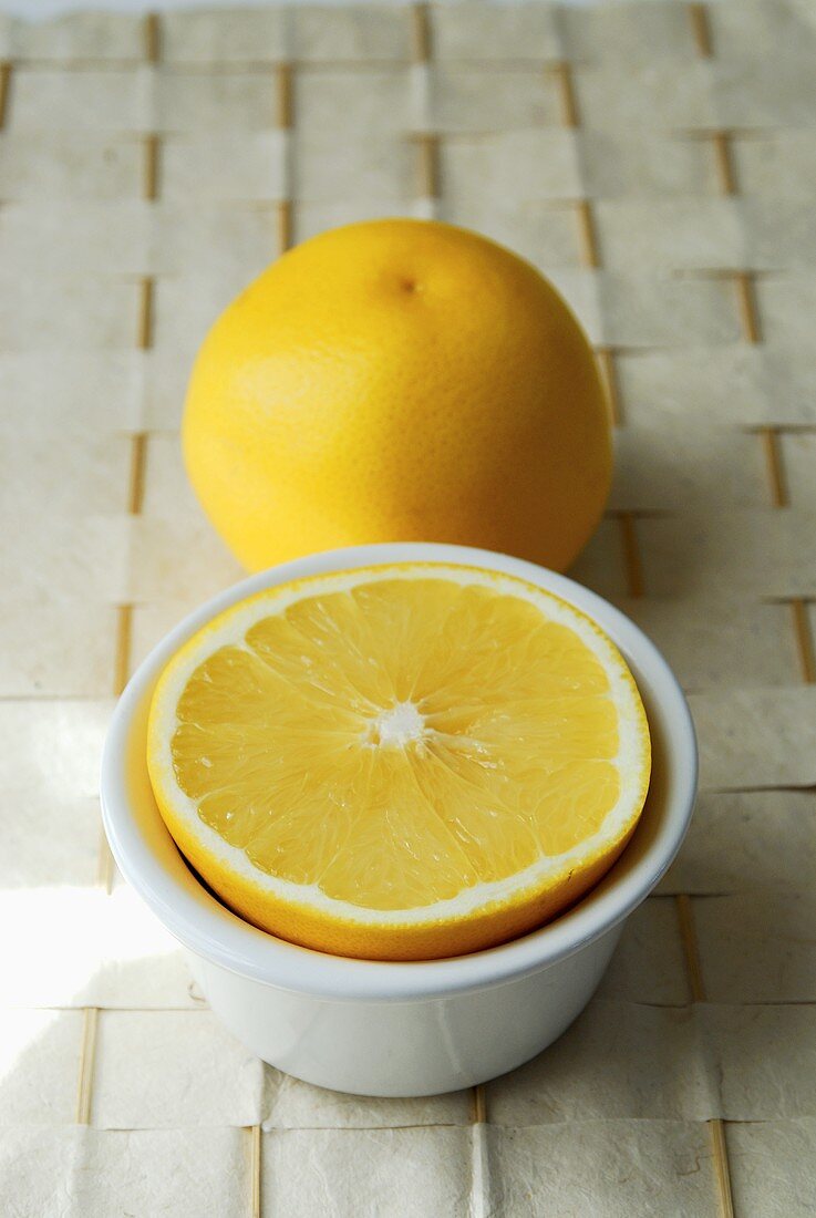 Grapefruit half in bowl and whole grapefruit