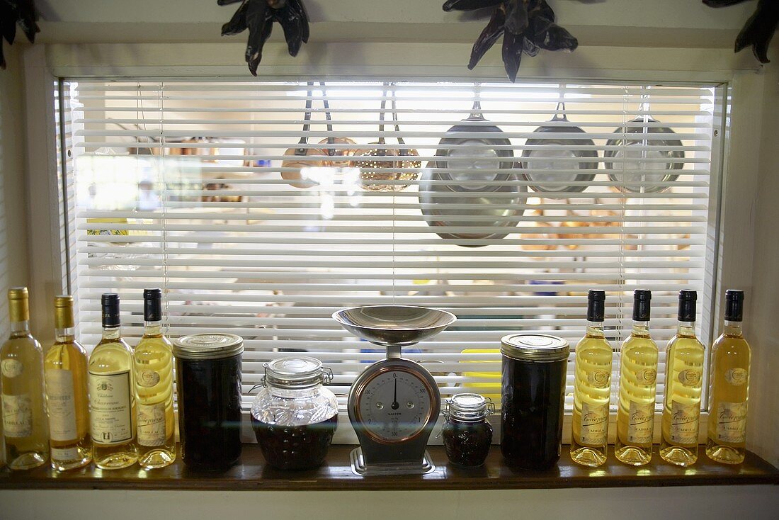 Fensterbank mit Weissweinflaschen und Blick in eine Küche
