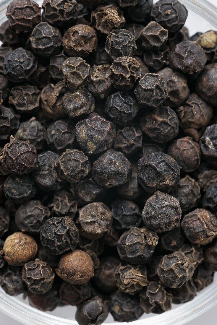 Black pepper in scoop, close-up