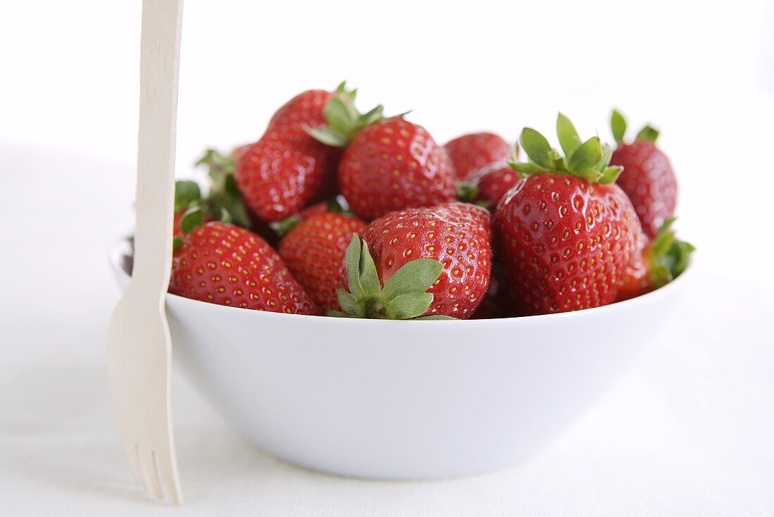 Fresh strawberries with small wooden fork