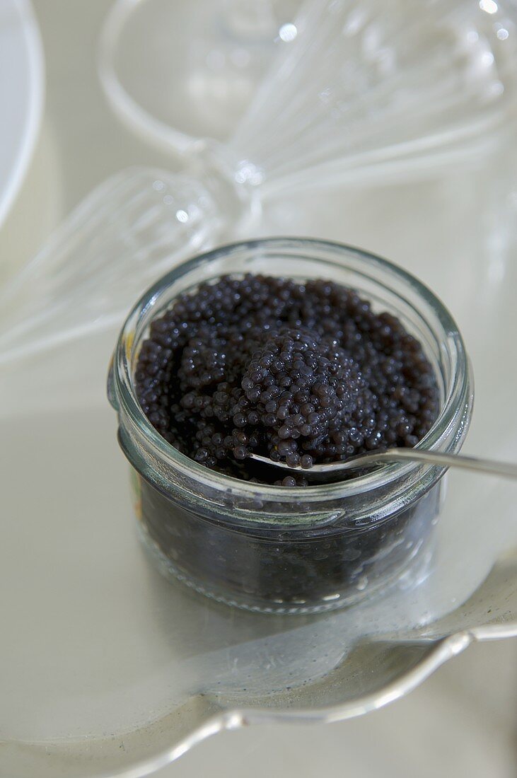 Schwarzer Kaviar mit Löffel im Glas