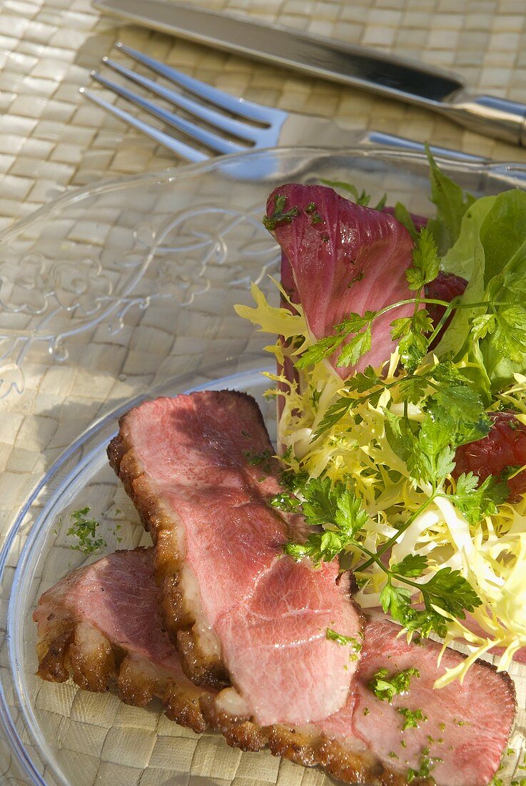 Salad leaves with duck breast and raspberries