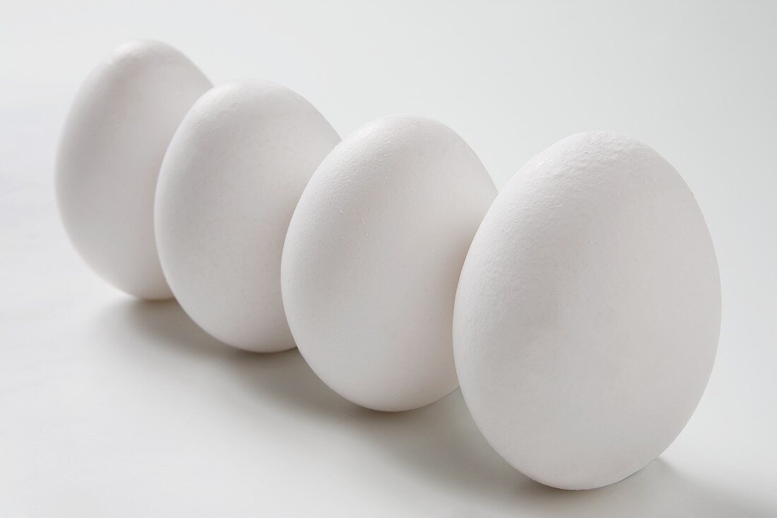 Vier weiße Eier in einer Reihe