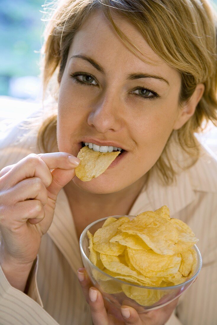 Blonde Frau isst Chips