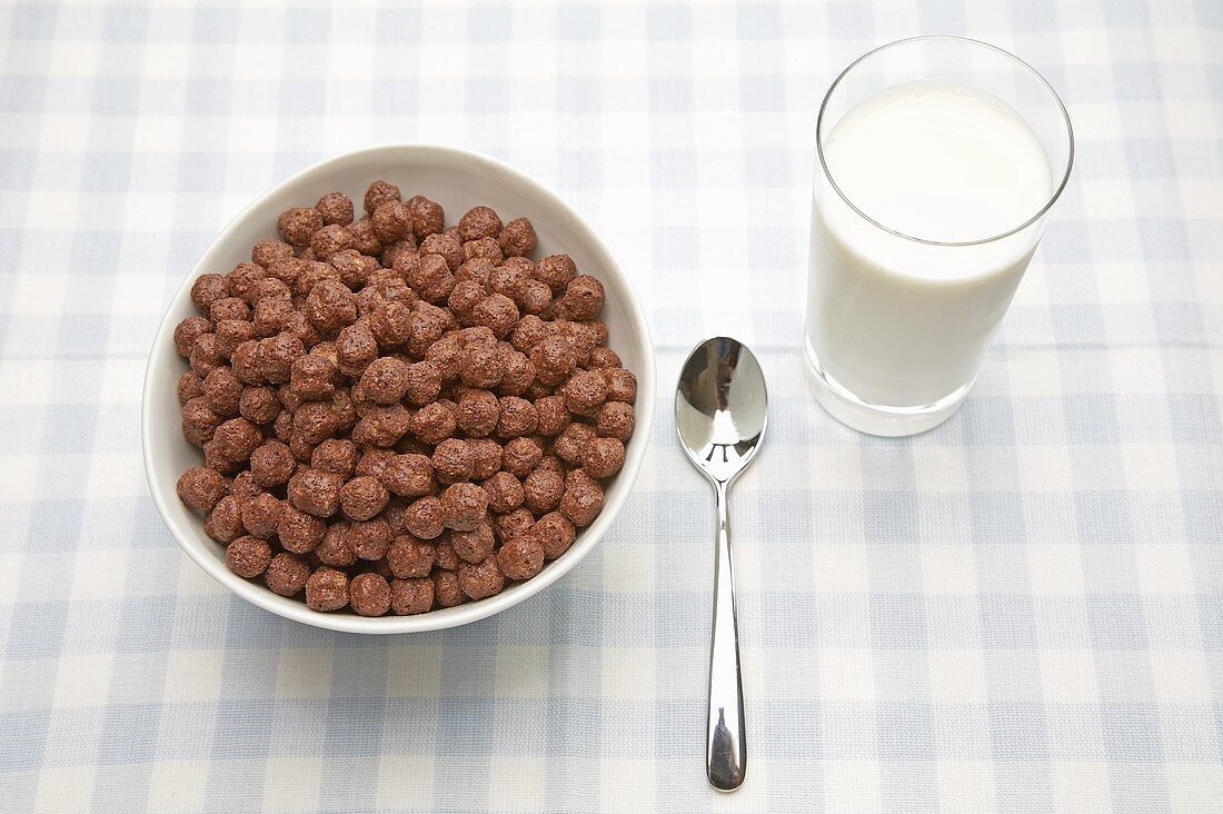 Breakfast cereal (chocolate-flavoured cereal balls) and a glass of milk
