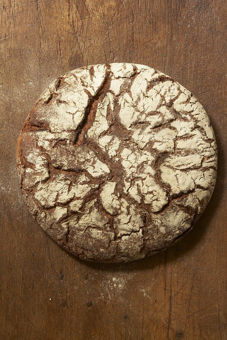 A loaf of rye bread on wooden background