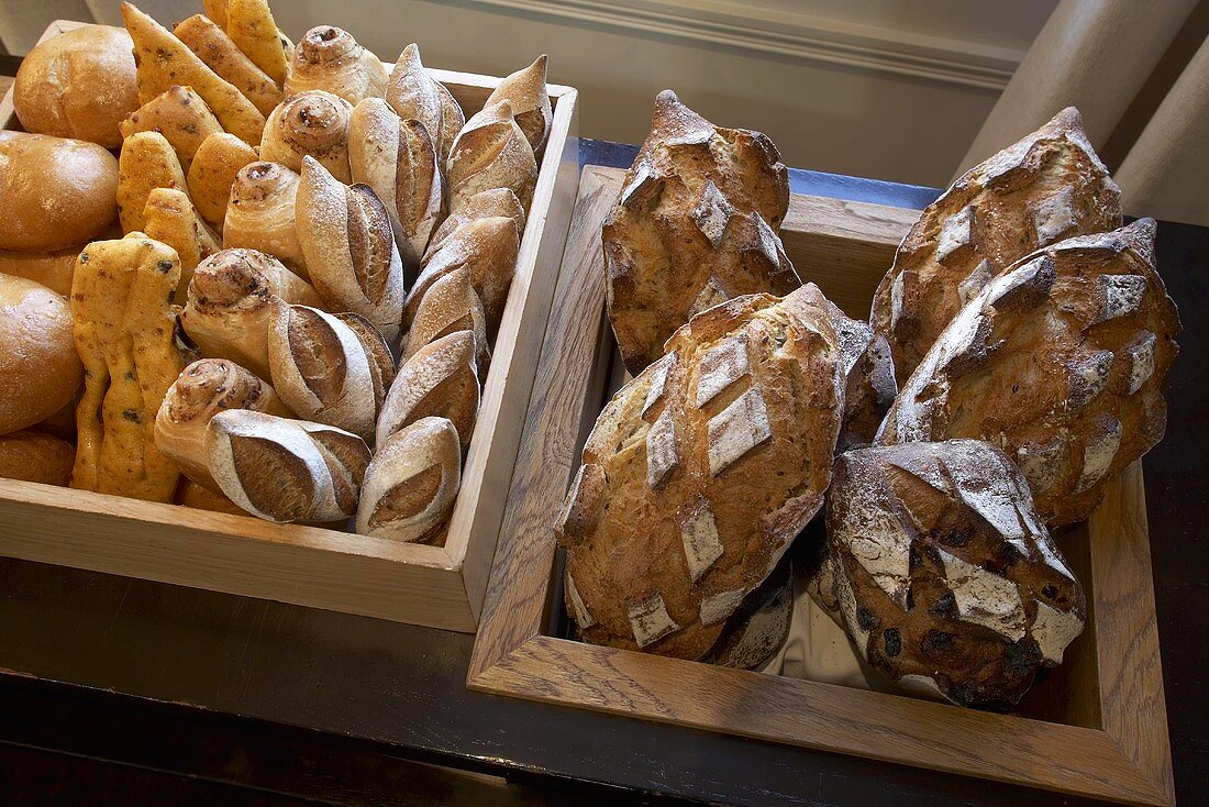 Verschiedene Brote und Brötchen in Holzkisten