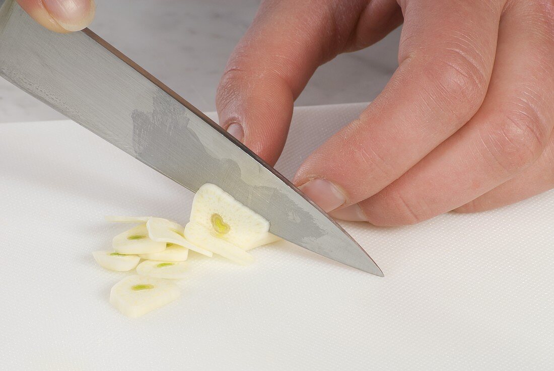 Slicing a clove of garlic
