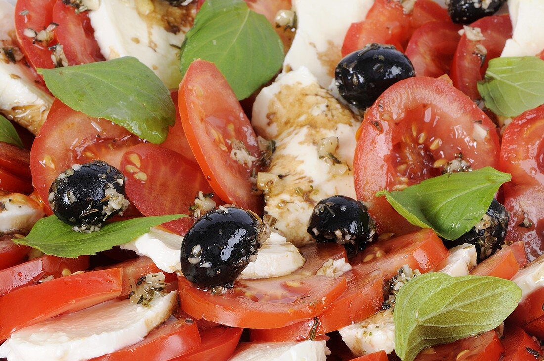 Tomatoes and mozzarella with black olives and basil