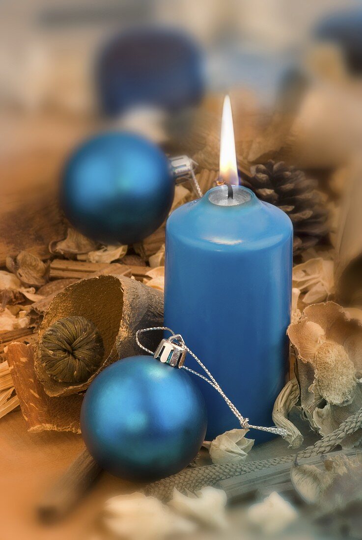 Blue candle with Christmas baubles