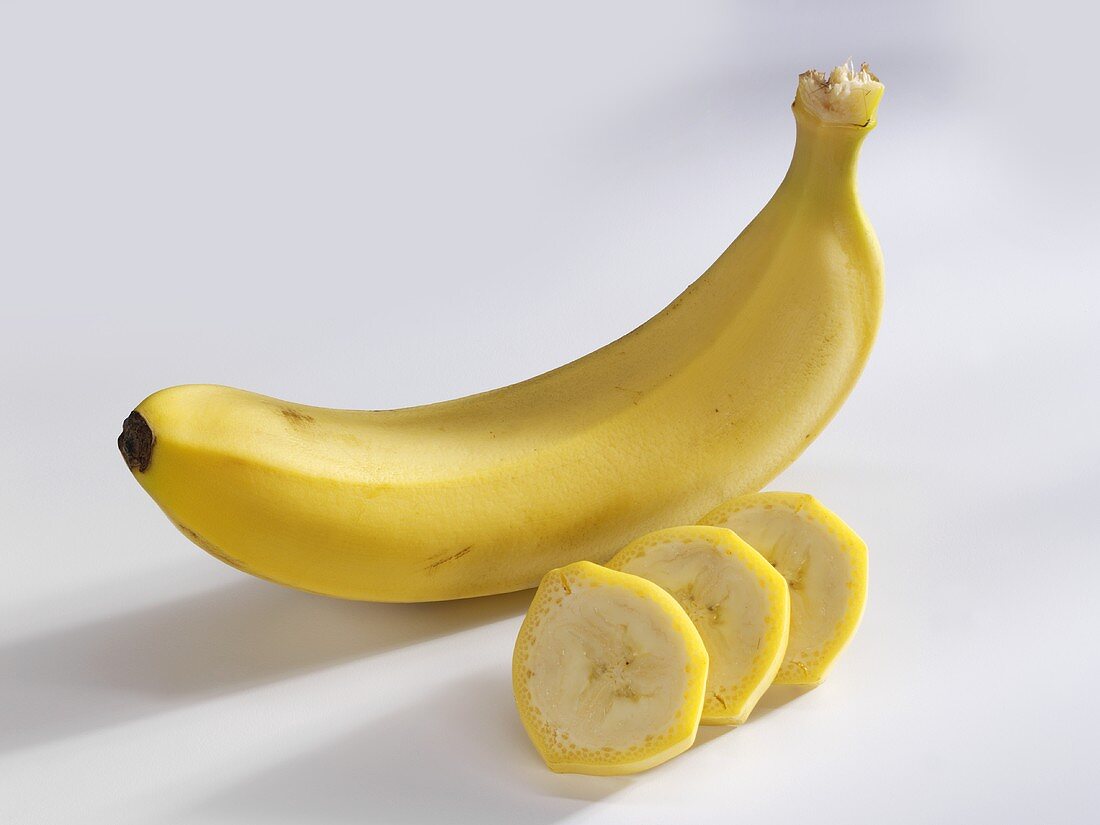 Eine ganze Banane und drei Bananenscheiben