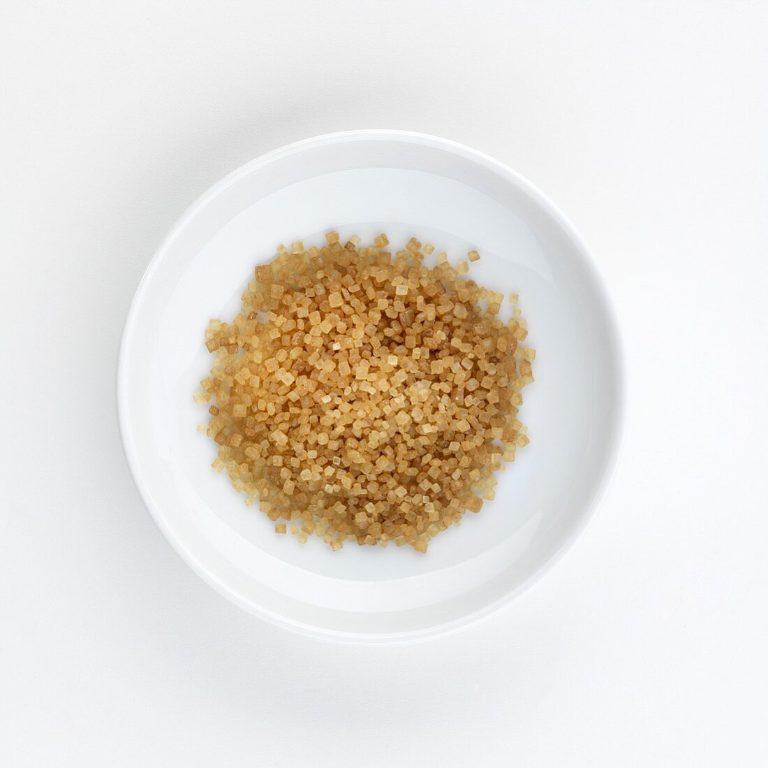 Brown cane sugar on a plate, seen from above