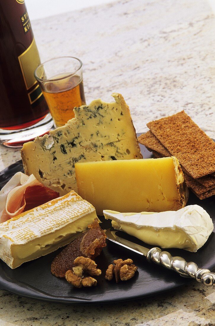Cheese platter with nuts, crispbread, raw ham and wine