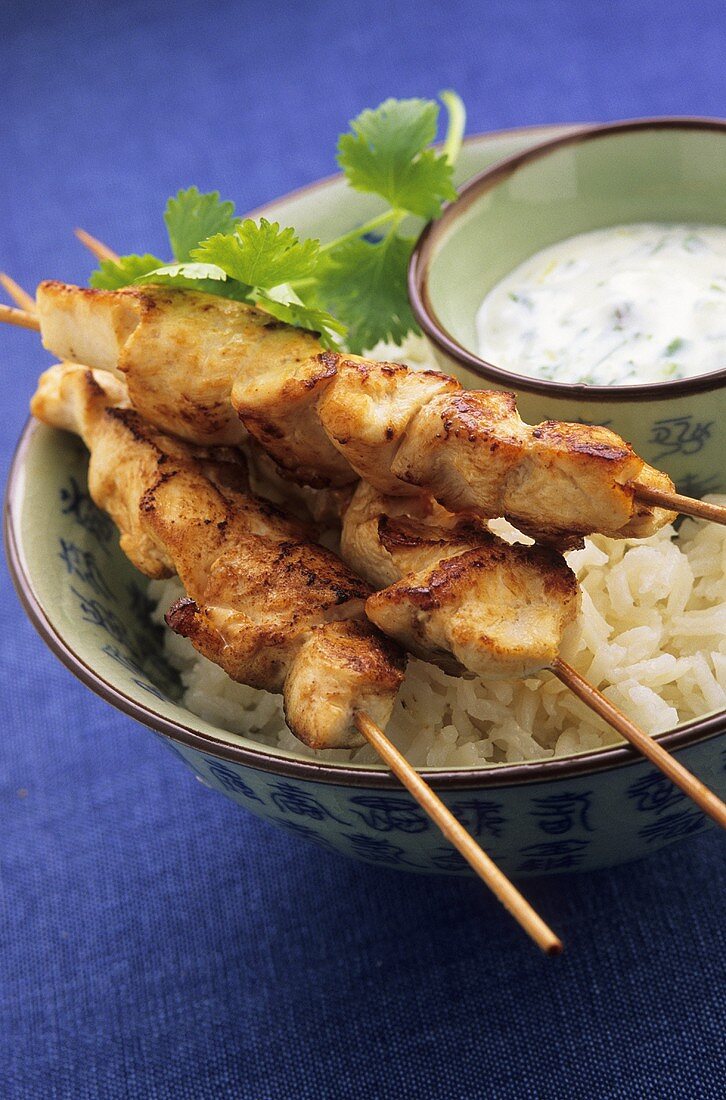 Chicken kebabs with rice and a yogurt sauce