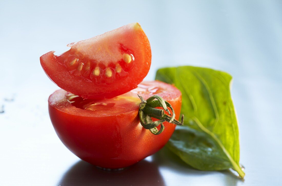 Angeschnittene Tomate mit einem Basilikumblatt
