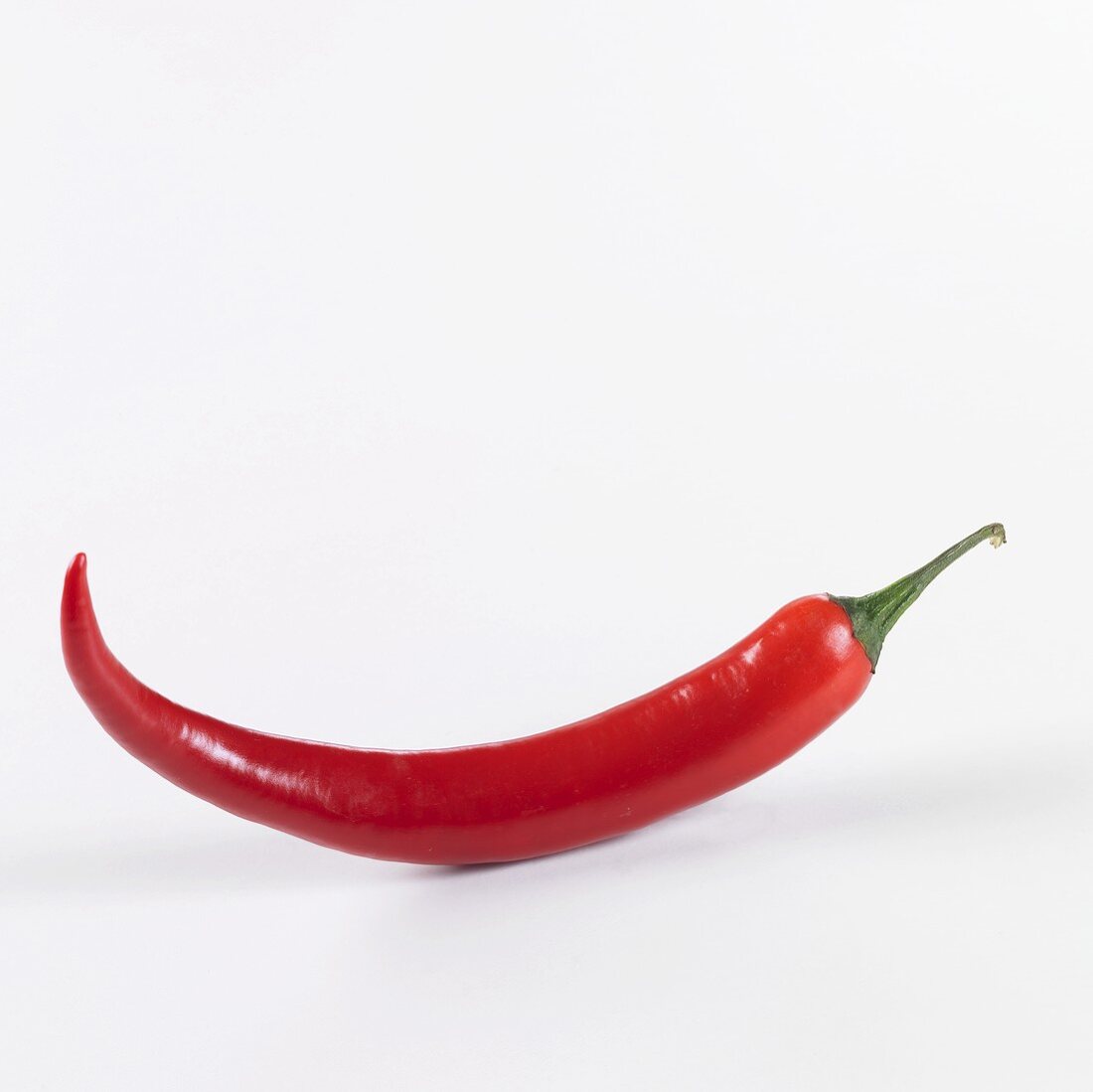 A red chilli against a white background