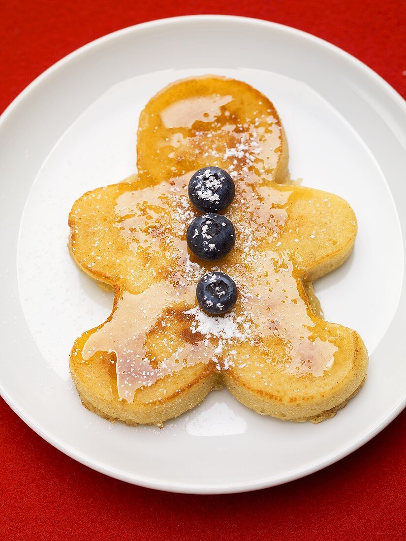Pancake man with blueberries and maple syrup