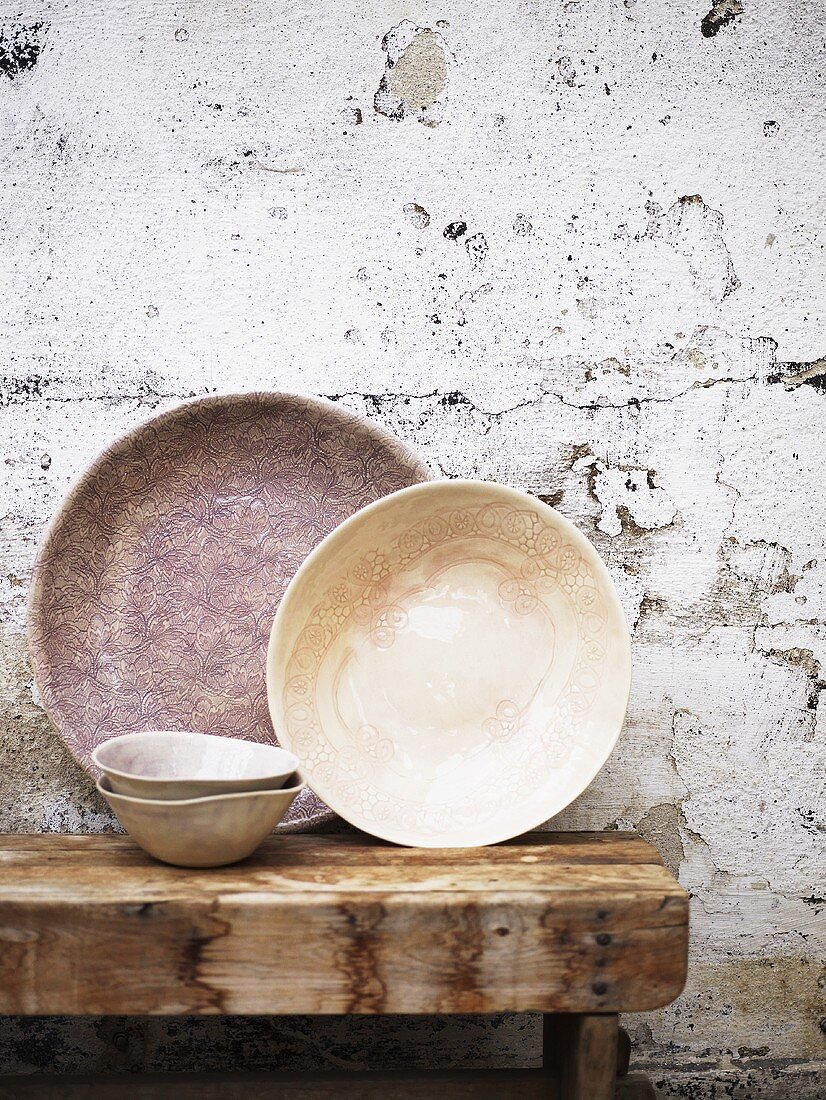 Old bowls on a wooden table on a wall