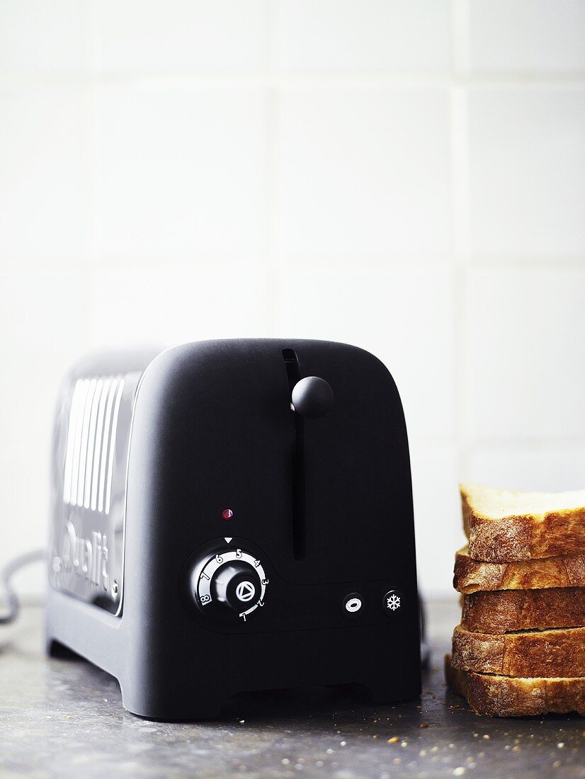 Toaster with slices of bread next to it