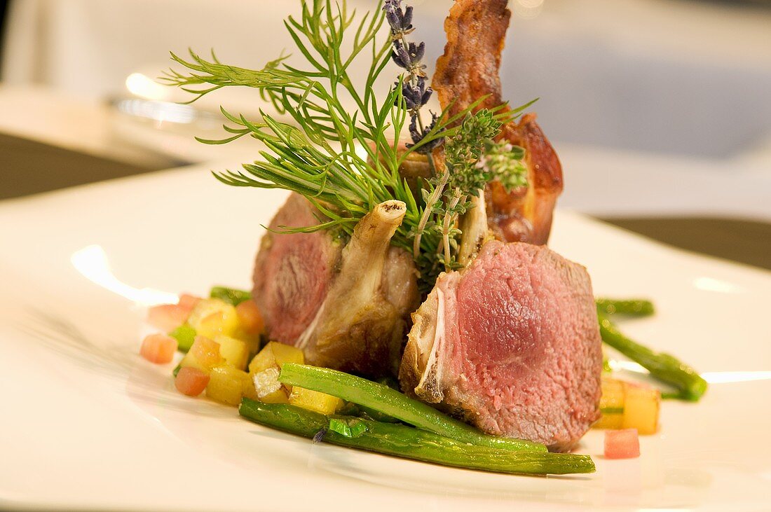 Lamb chops with herbs on vegetables and beans