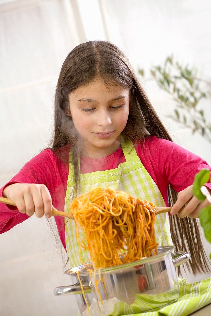 Mädchen vermischt Spaghetti mit Sauce Bolognese