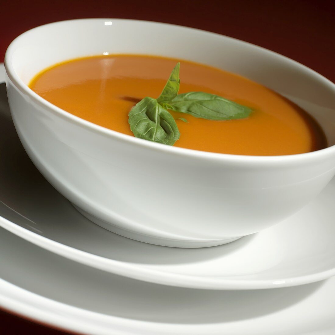 Tomato soup with basil in a soup bowl