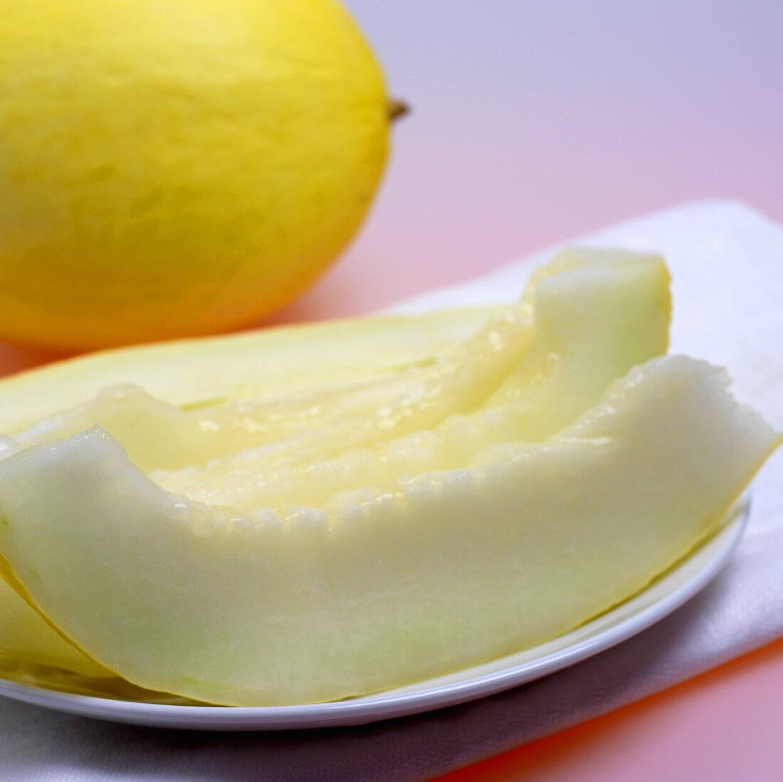 Whole honeydew melon and slices of melon
