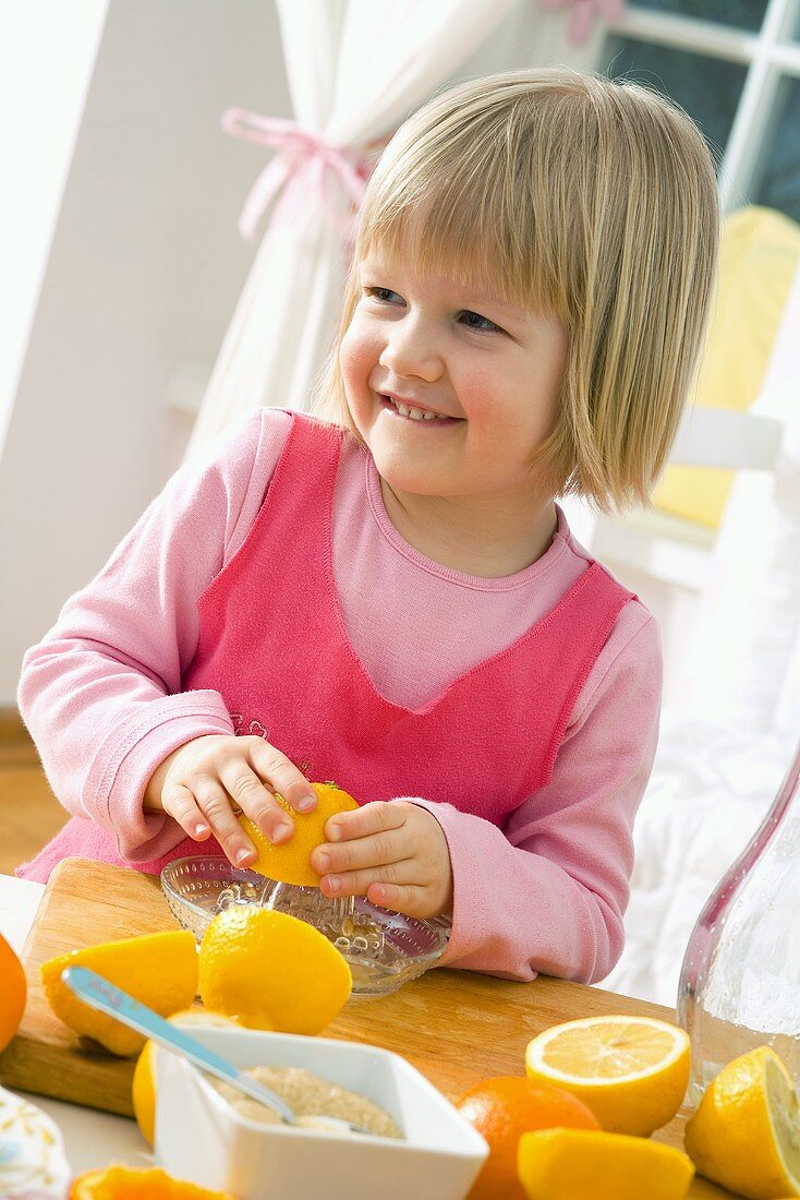 Kleines Mädchen presst Zitronen aus
