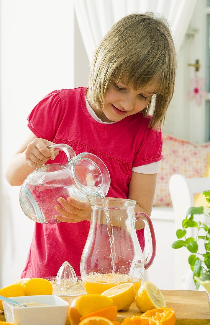 Girl making orange lemonade