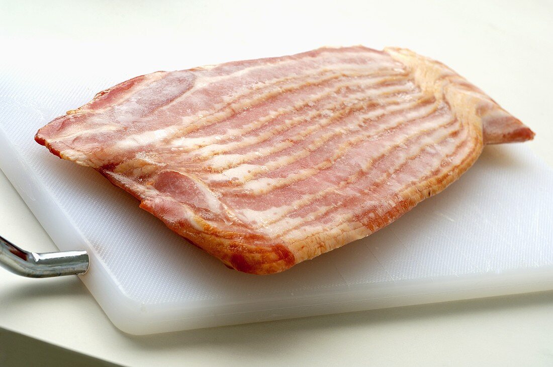 Frozen, sliced bacon on chopping board