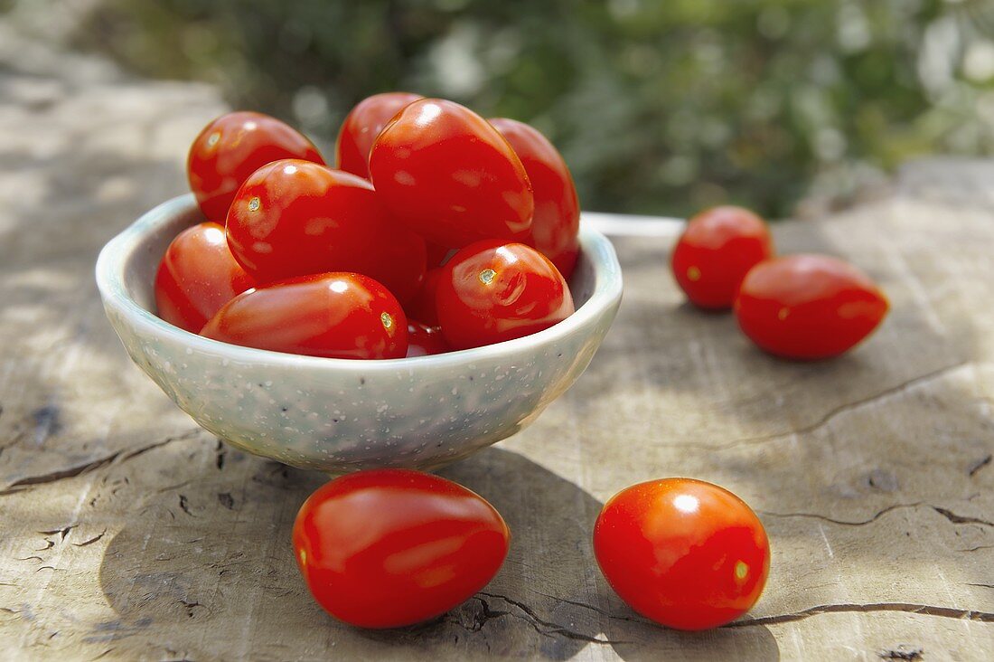 Plum tomatoes in and beside a dish