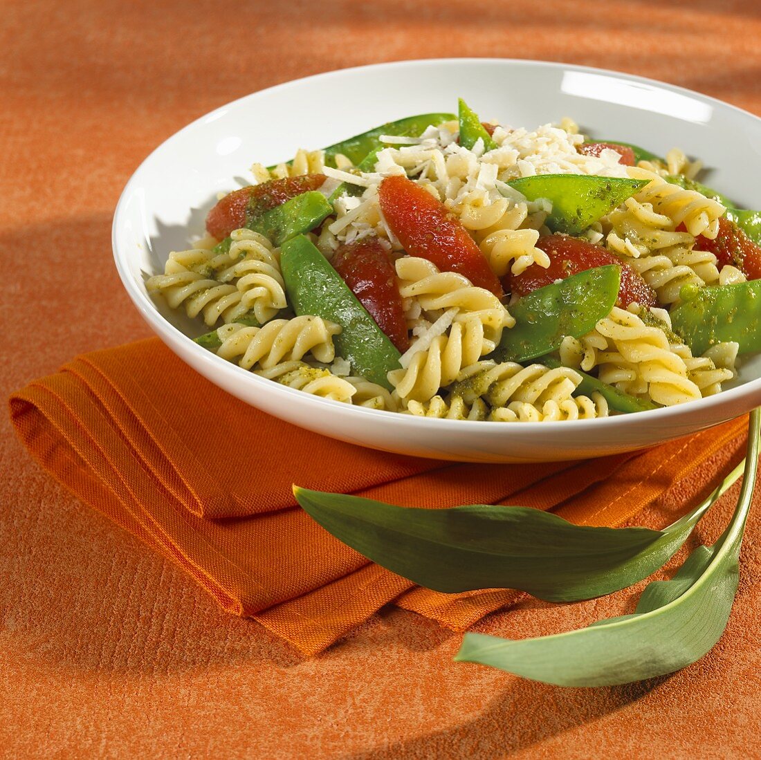 Pasta spirals with ramsons pesto, mangetout and tomatoes