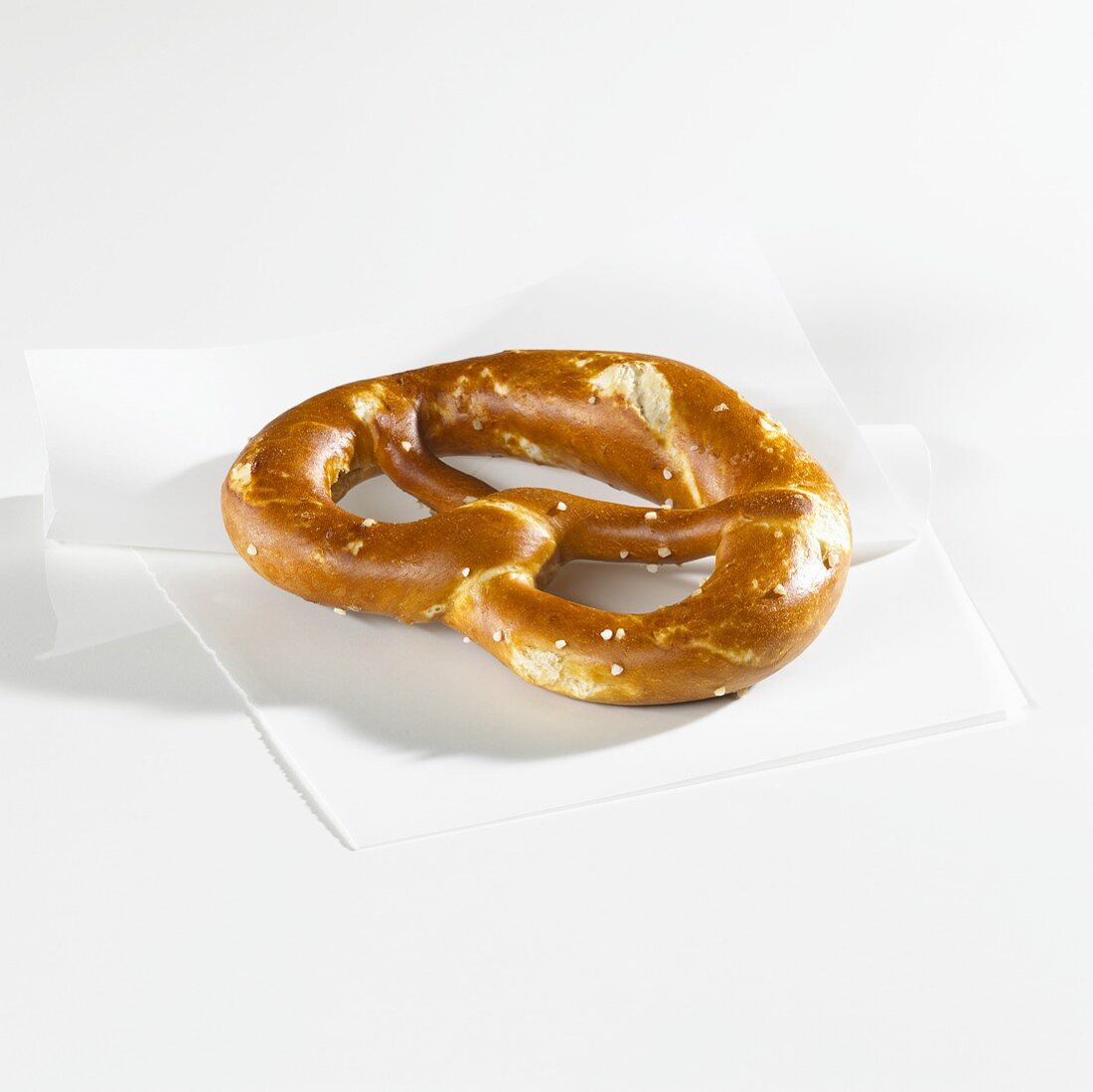 A pretzel on greaseproof paper