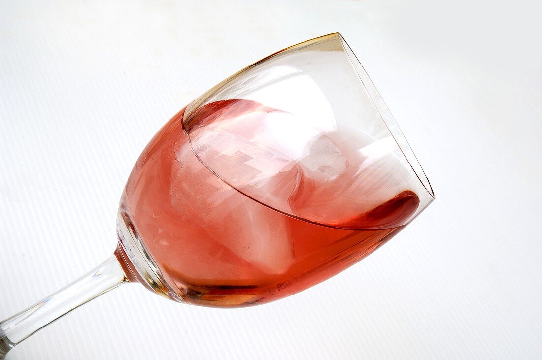 A glass of rosé wine with ice cubes