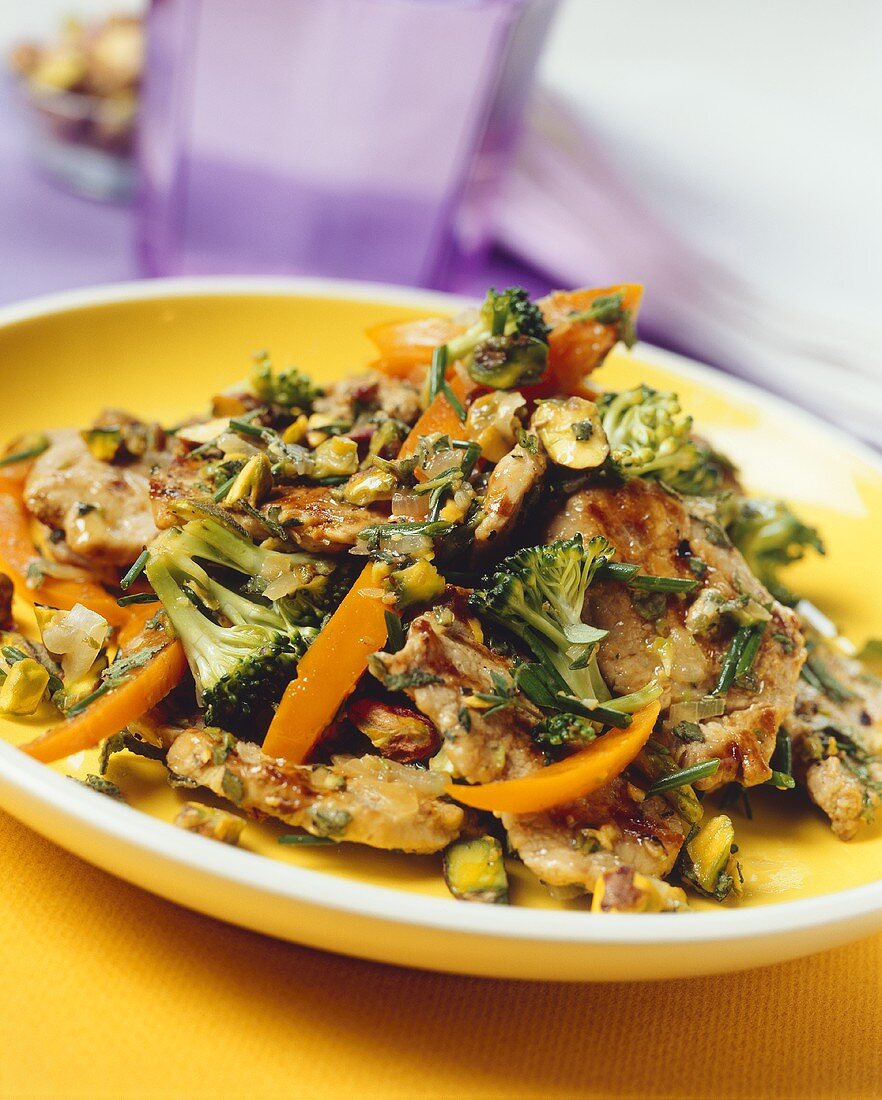 Fried pork fillet with vegetables, herbs and pistachios