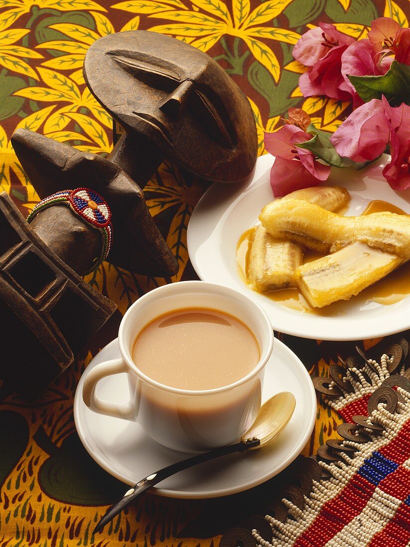 Baked bananas, coffee and wooden African figure